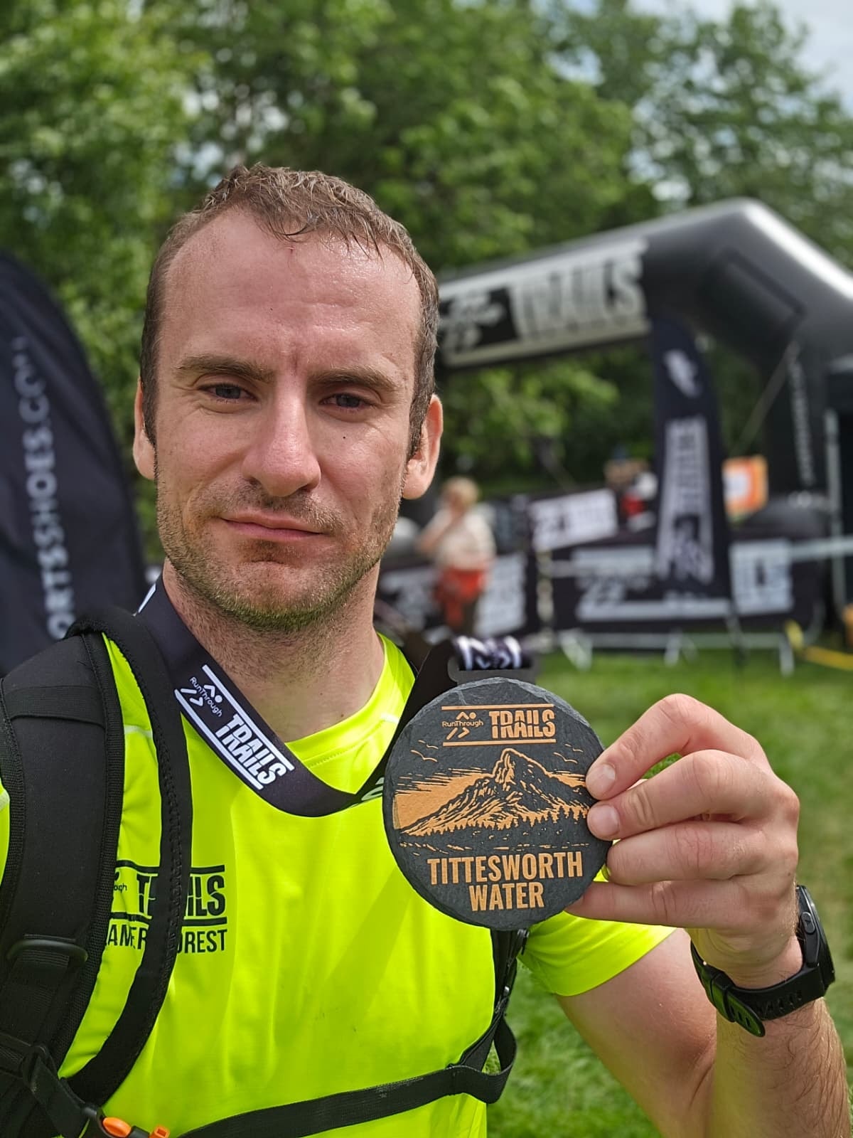 Runner proudly holding their race medal